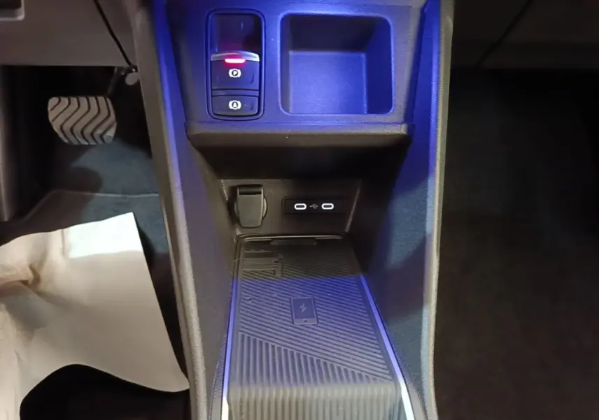 Vue rapprochée de la console centrale intérieure de la Renault R5 électrique 2024, avec chargeur sans fil et ports USB.