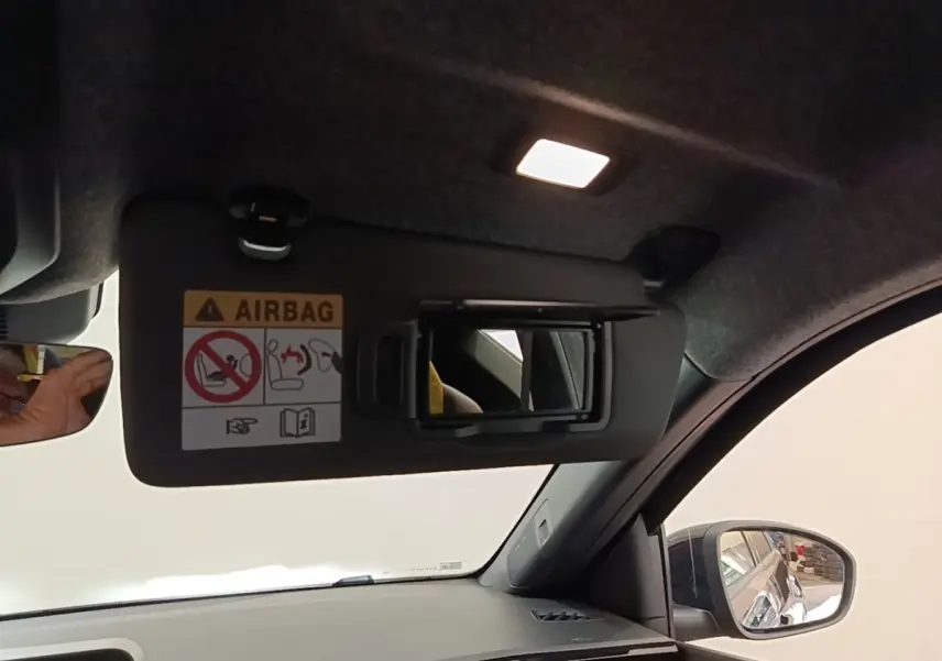 Intérieur de la Renault R5 électrique 2024, vue côté droit sur pare-soleil avec miroir et tableau de bord gris.