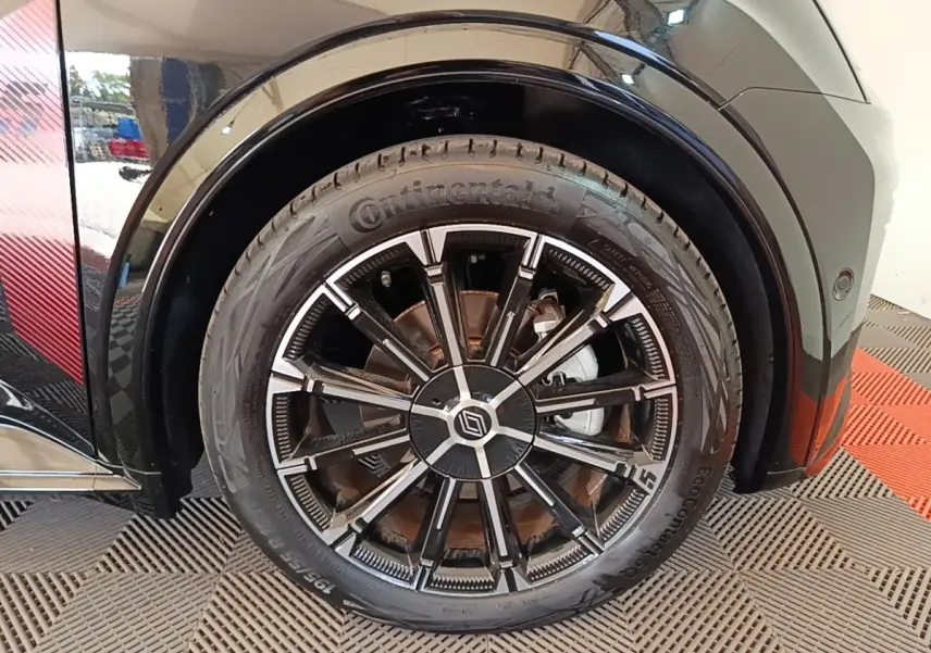 Gros plan sur la roue avant droite noire d'une Renault R5 Iconic 2024 avec jante design bicolore et pneu Continental.