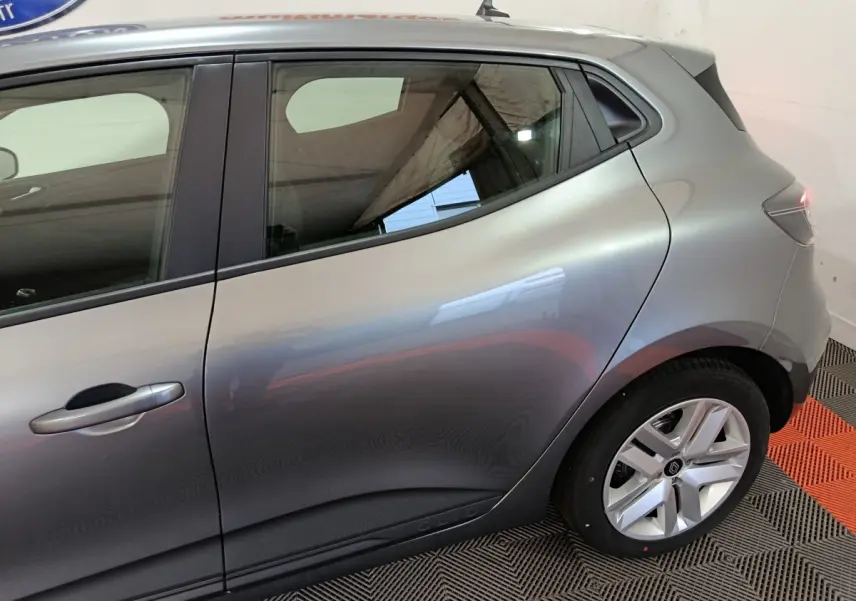 Vue latérale côté gauche d'une Renault Clio gris clair 2025, mettant en valeur la porte arrière et la jante alliage.