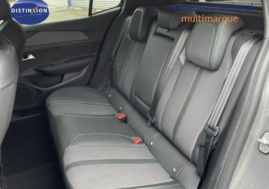 Vue intérieure côté droit montrant la banquette arrière en tissu et cuir gris avec surpiqûres vertes du Peugeot 408 2025.