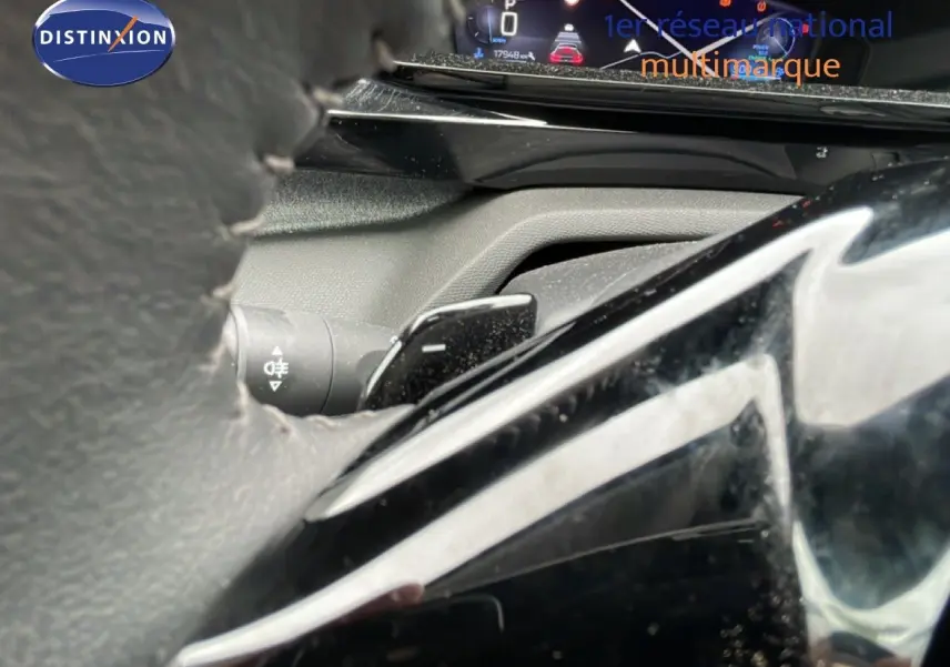 Gros plan sur le levier de vitesses et le tableau de bord numérique d’une Peugeot 408 gris selenium, côté conducteur.