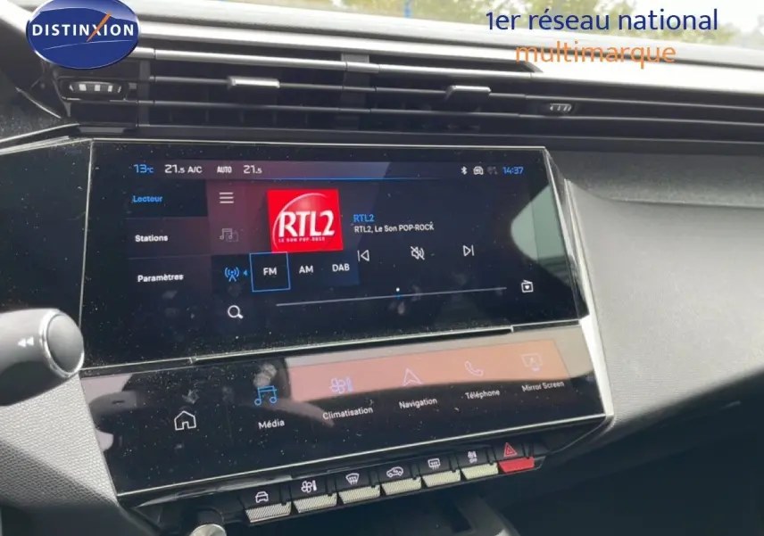 Vue rapprochée de l’écran tactile central du tableau de bord de la Peugeot 408 gris Selenium, affichant la radio RTL2.