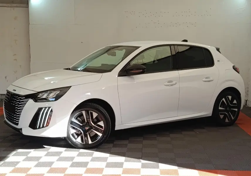 Peugeot 208 électrique blanche vue de profil côté gauche dans un garage avec jantes distinctives bicolores.