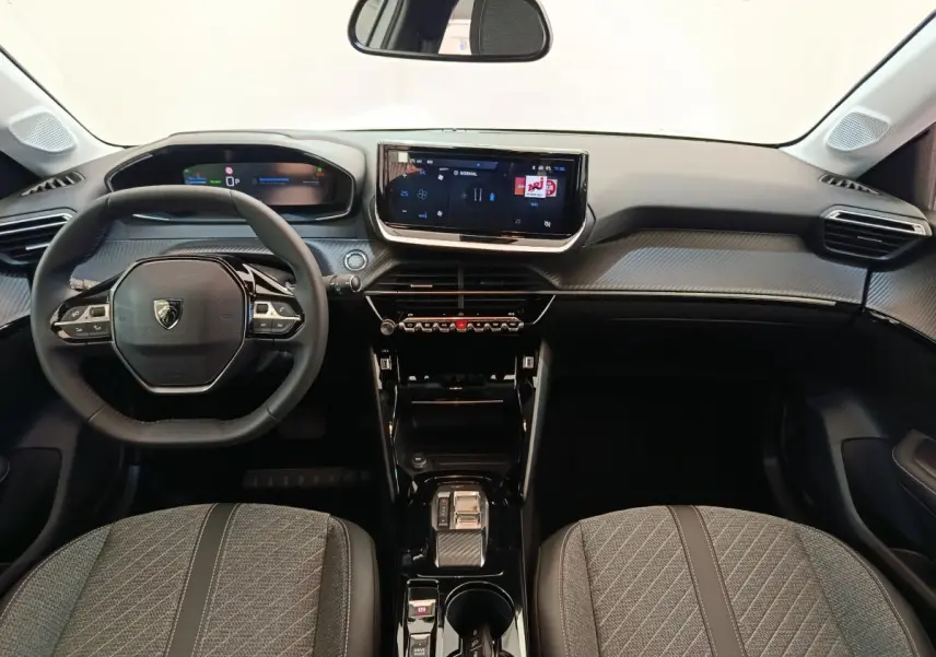 Vue intérieure avant de la Peugeot 208 électrique 2024, tableau de bord noir avec écran tactile central et volant compact cuir.