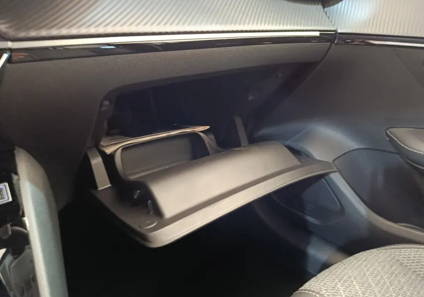 Vue intérieure du coffre à gants ouvert côté passager de la Peugeot 208 électrique blanche 2024.
