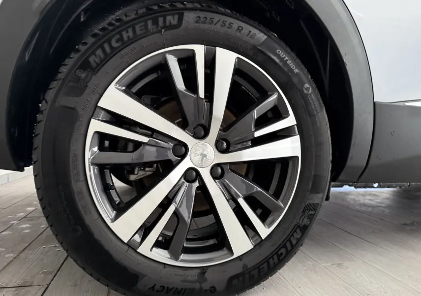 Gros plan sur la roue avant gauche du Peugeot 3008 gris Artense métal, mettant en valeur la jante alliage et le pneu Michelin.