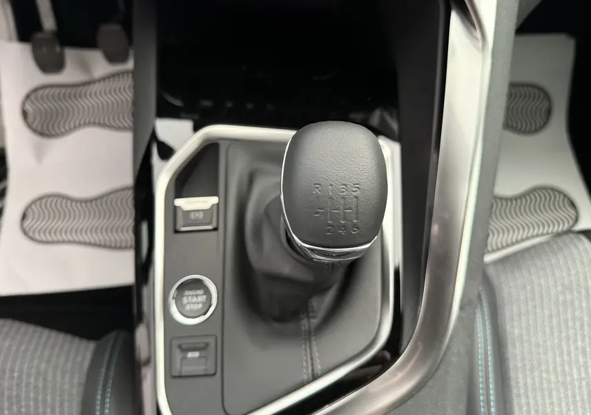 Gros plan sur le levier de vitesse manuel entouré de la console noire et argentée du Peugeot 3008 gris Artense 2023.