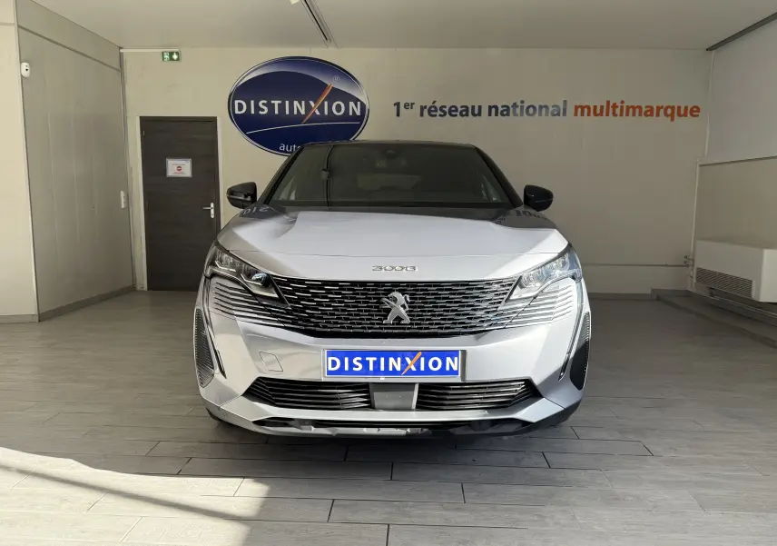 Vue frontale d'un Peugeot 3008 gris Artense métal dans un showroom avec logo Distinxion en arrière-plan.