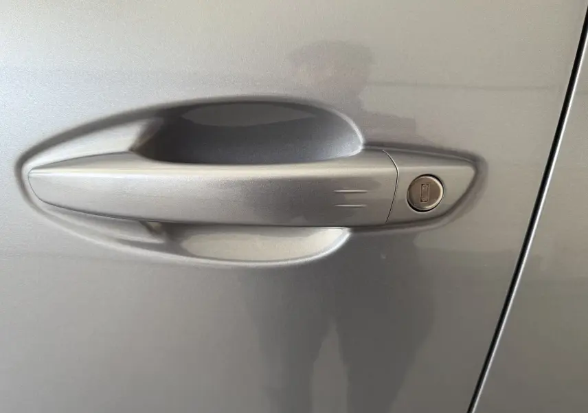 Poignée de porte côté droit gris Artense métal du Peugeot 3008 2023 avec serrure intégrée visible.