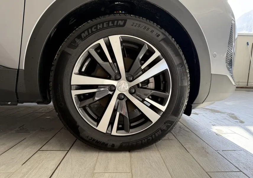 Gros plan sur la roue avant droite du Peugeot 3008 gris Artense métal avec jante alliage et pneu Michelin.