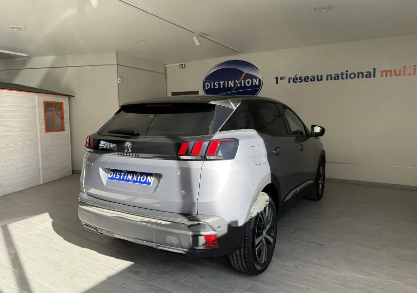 Vue 3/4 arrière droite d'un Peugeot 3008 gris Artense métal avec vitres teintées et feux arrière à griffes rouges.