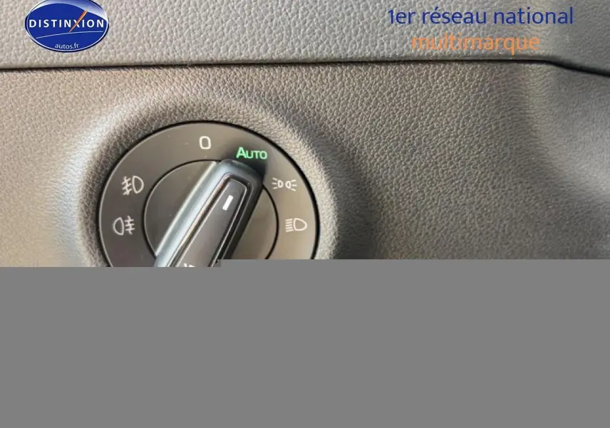 Gros plan sur la molette de réglage des phares dans l'habitacle gris du Skoda Karoq 2025.