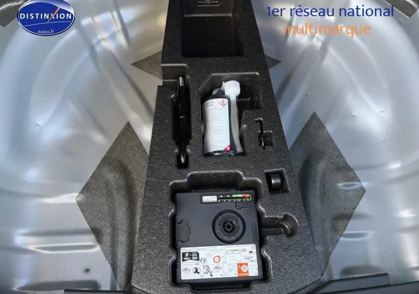 Vue plongeante sur le coffre avec kit de réparation pneu intégré d'une Skoda Karoq gris 2025.