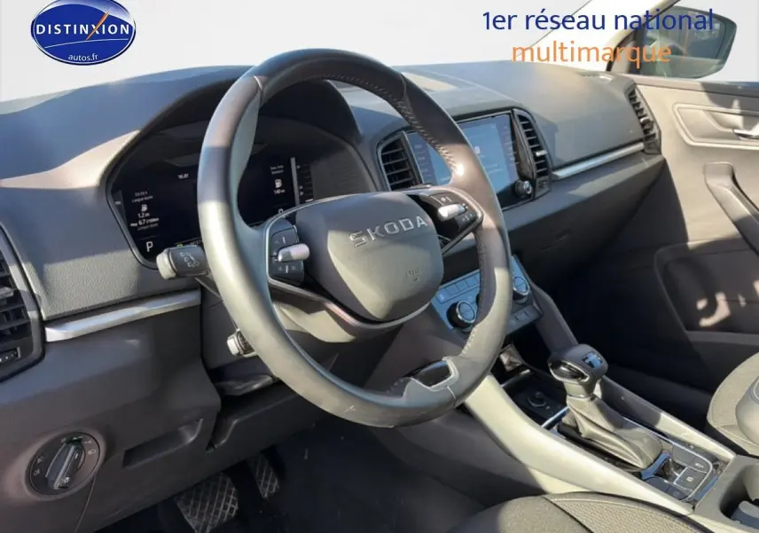 Vue intérieure côté conducteur du Skoda Karoq gris 2025, montrant volant multifonction et console centrale avec boîte auto.