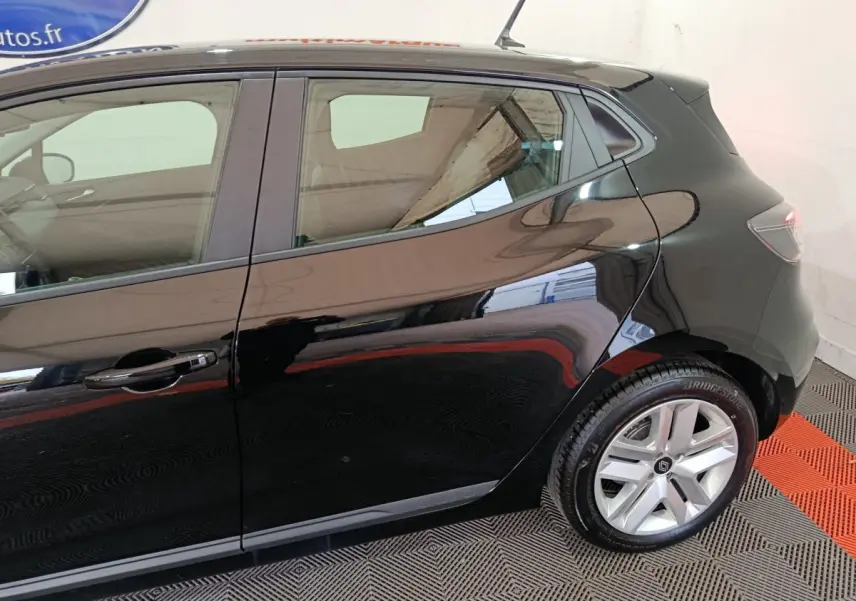 Vue latérale droite d’une Renault Clio noire 2025, mettant en valeur la porte arrière et la roue arrière avec jante argentée.