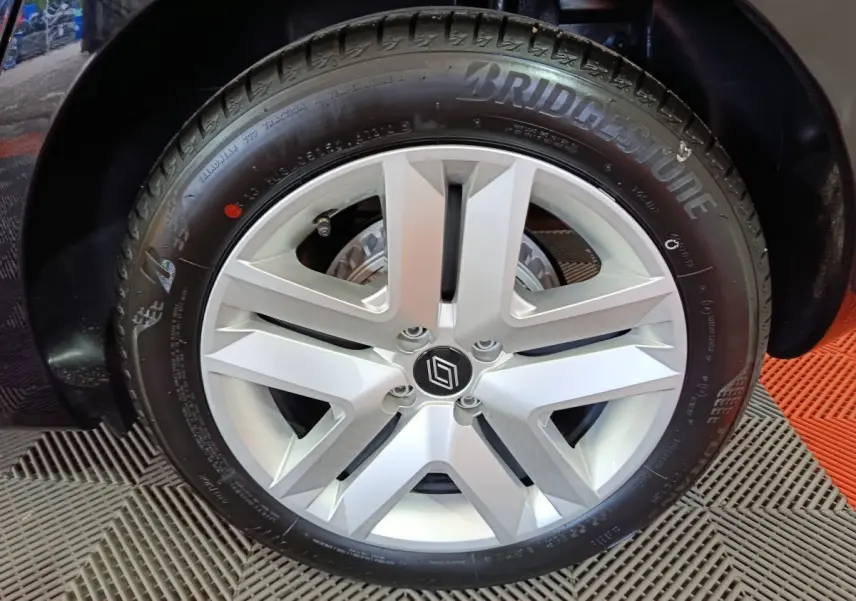 Gros plan sur la roue arrière droite noire d'une Renault Clio Evolution Blue dCi 100, avec passage de roue visible.