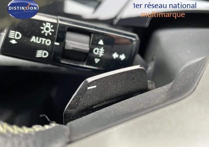 Gros plan sur la commande des feux et le levier de vitesse au volant du Peugeot 3008 gris Artense 2025.