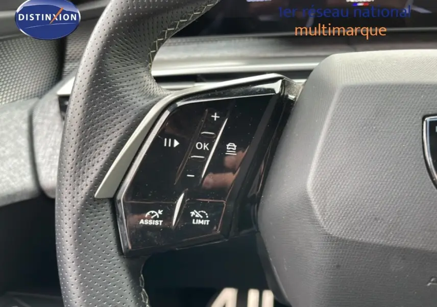 Gros plan sur le volant cuir perforé du Peugeot 3008 gris Artense, avec commandes d'assistance et limitation de vitesse.