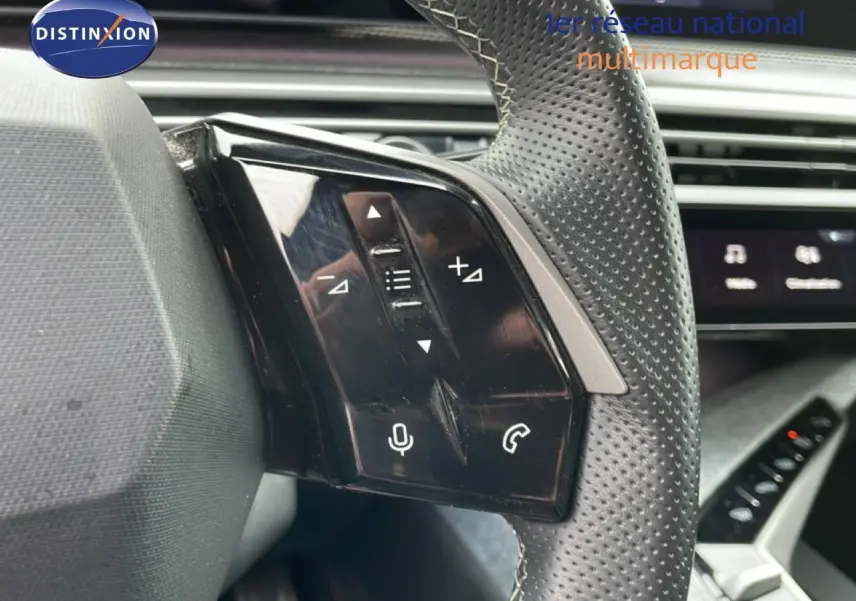 Gros plan sur les commandes gauche du volant perforé gris noir du Peugeot 3008 2025, avec touches audio et téléphone.