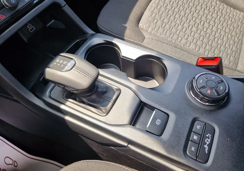 Gros plan intérieur sur la console centrale du Ford Ranger Super Cabine, levier de boîte auto et commandes 4x4 visibles.