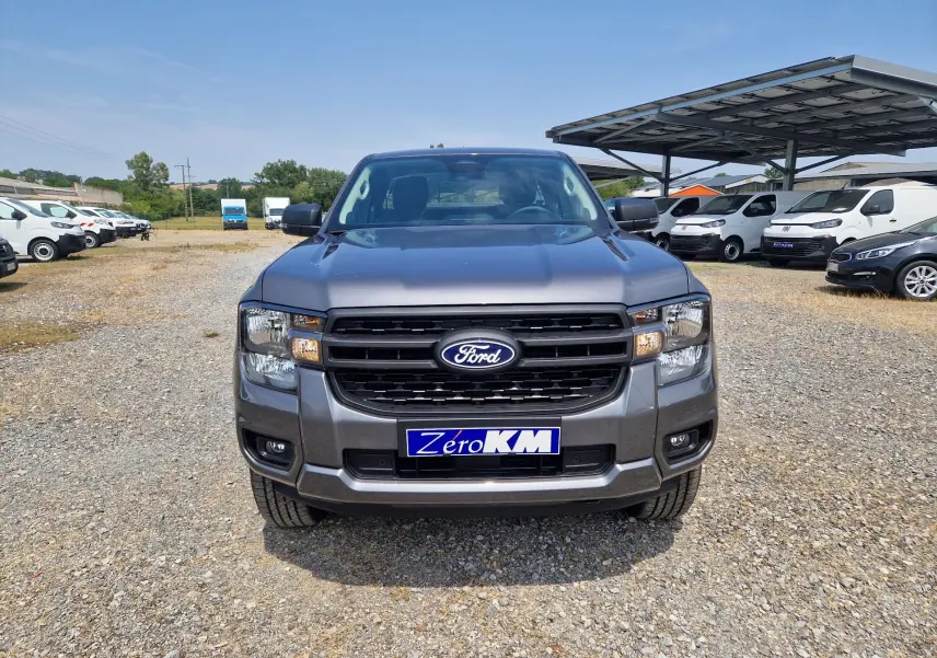 Vue frontale du Ford Ranger Super Cabine gris carbone, mettant en valeur sa calandre noire et ses optiques carrées.