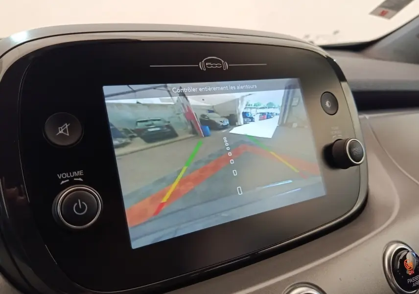 Écran tactile intérieur montrant la caméra de recul d'une Fiat 500X gris foncé, vue de face du tableau de bord.