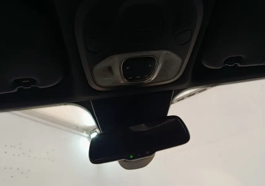 Vue intérieure du rétroviseur central et plafonnier avec commandes lumineuses du Fiat 500X gris foncé 2021.