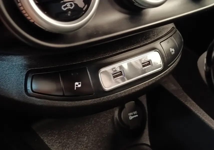 Gros plan sur les ports USB et boutons de commande du tableau de bord noir du Fiat 500X gris foncé 2021.