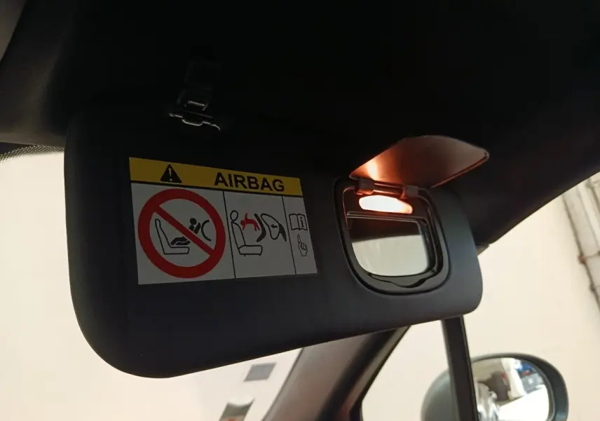 Détail du pare-soleil côté conducteur avec miroir éclairé dans l’habitacle sombre d’un Fiat 500X gris foncé.