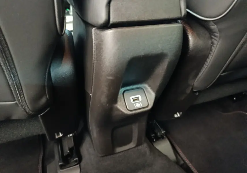 Prise USB arrière intégrée au bas de la console centrale, entre les sièges noirs du Fiat 500X gris foncé.