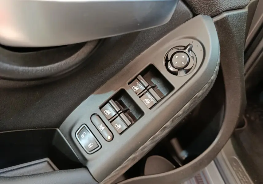 Commande des vitres électriques et réglage des rétroviseurs côté conducteur dans une Fiat 500X gris foncé, vue intérieure rapprochée.