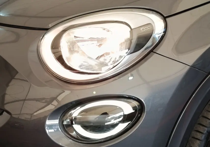 Gros plan sur les phares avant droit gris foncé d'une FIAT 500X 2021 avec éclairage LED et logo 500C visible.