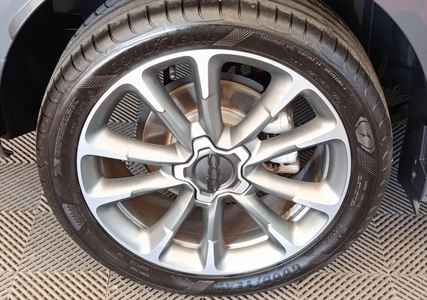 Gros plan sur la jante alliage grise et le pneu Goodyear d’un FIAT 500X gris foncé, vue côté roue avant.