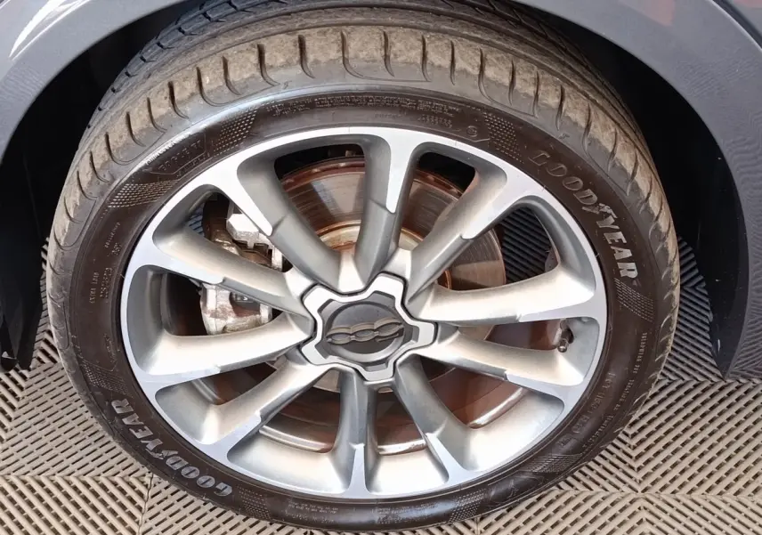 Gros plan sur la roue avant gauche gris foncé d’un FIAT 500X avec jante alliage et pneu Goodyear.