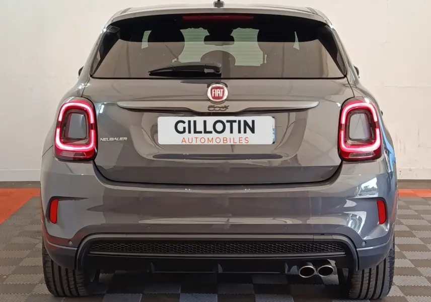 Vue arrière d'une FIAT 500X gris foncé avec feux LED allumés et double sortie d'échappement à droite.