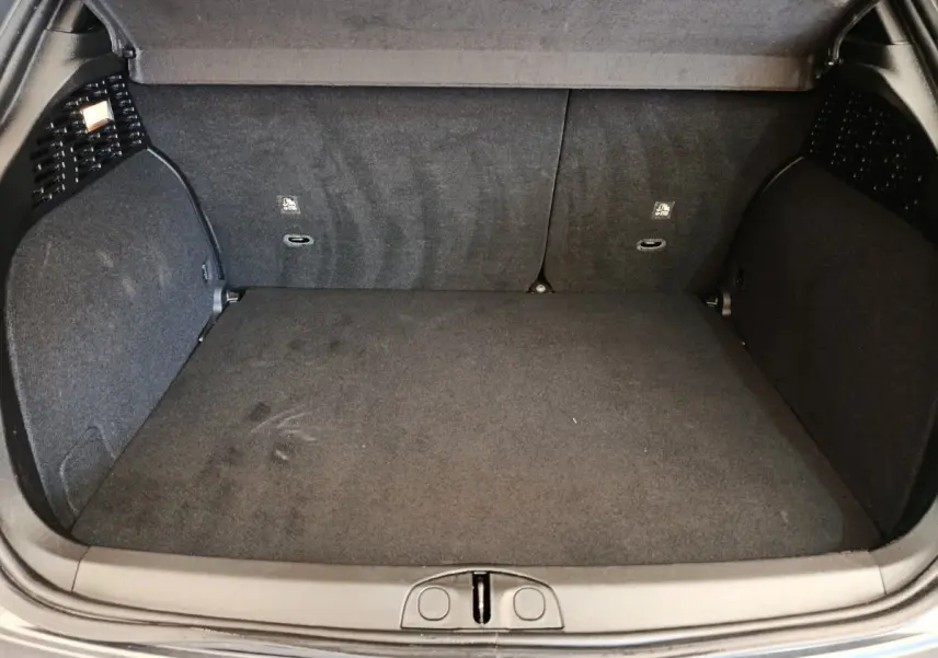 Coffre ouvert de la FIAT 500X gris foncé, vue intérieure montrant la surface plane et les parois en tissu noir.