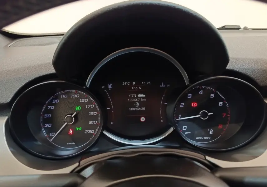Vue rapprochée du tableau de bord de la Fiat 500X 2021, affichage digital central et compteurs analogiques noirs.