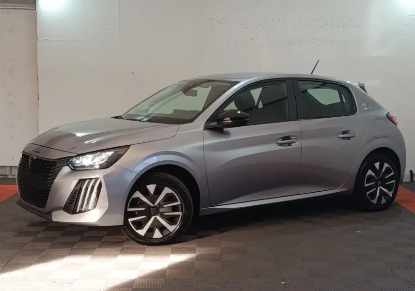 Peugeot 208 électrique gris clair vue de profil droit, avec phares LED et jantes stylisées noires et argent.
