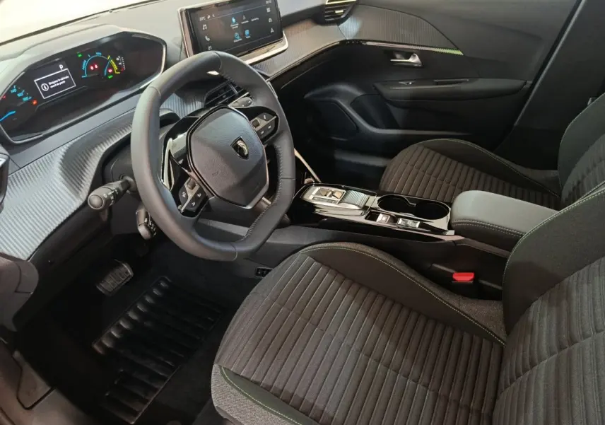 Intérieur avant droit de la Peugeot 208 électrique gris clair, volant cuir multifonctions et écran tactile central.
