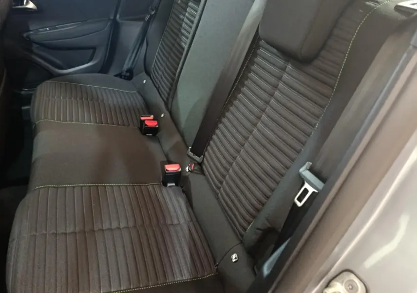 Vue côté droit sur la banquette arrière noire avec coutures vertes d’une Peugeot 208 électrique gris clair 2024.