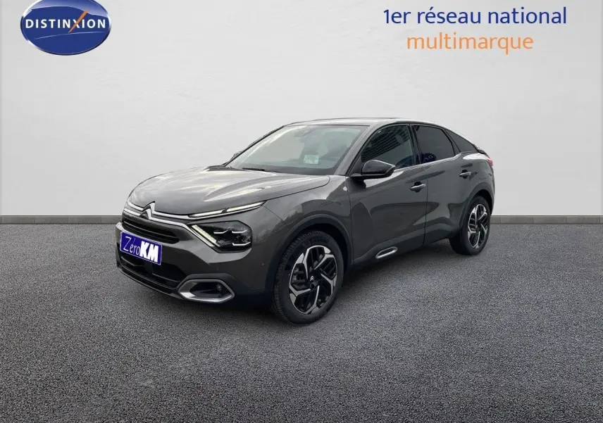 Citroën C4 gris platinium métal en 3/4 avant droit, mettant en valeur ses lignes modernes et ses jantes bicolores.