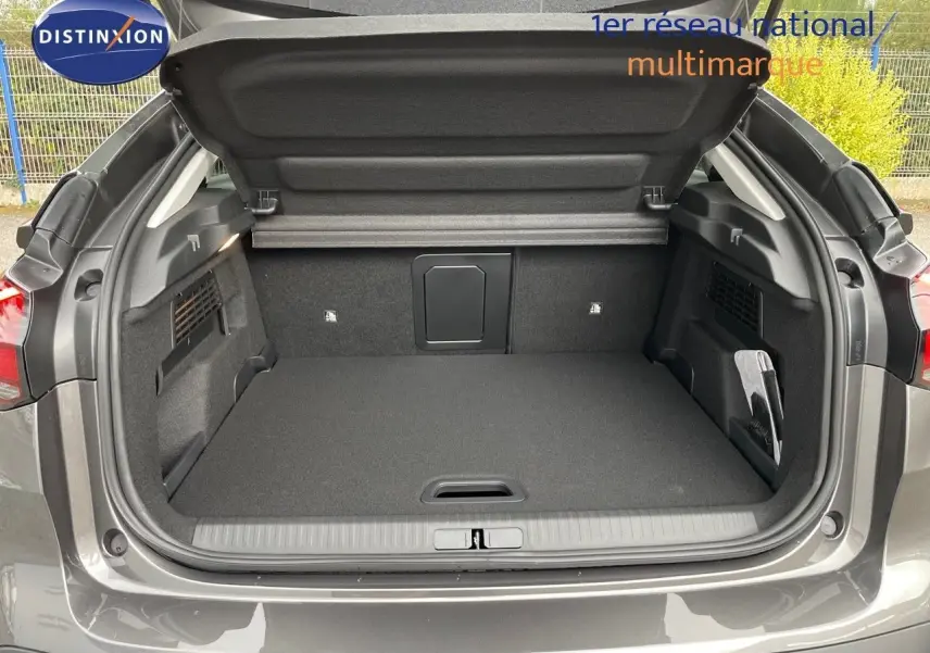 Coffre ouvert vu de l'arrière d'une Citroën C4 gris platinium métal, montrant un espace de chargement propre et spacieux.