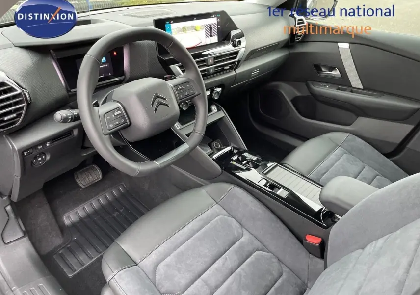 Intérieur moderne de la Citroën C4 2024, vue côté conducteur, sièges gris cuir et alcantara, tableau de bord avec écran tactile.