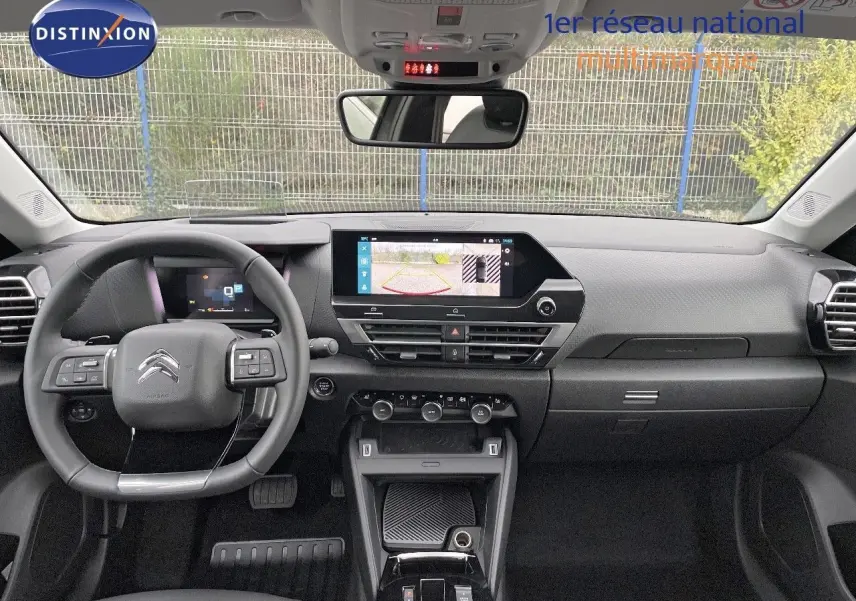 Intérieur du Citroën C4 2024 en gris, vue frontale du tableau de bord avec écran tactile et volant multifonction.