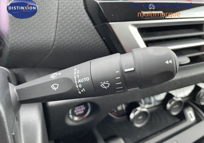 Gros plan sur la commande d'essuie-glace à gauche du volant dans l'habitacle d'une Citroën C4 gris platinium 2024.