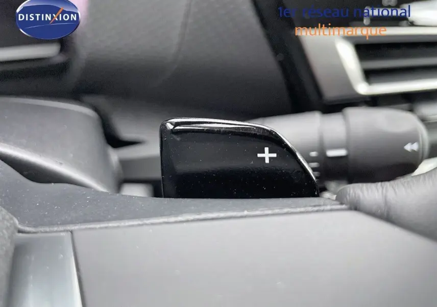 Gros plan sur la palette de changement de vitesse "+" côté droit du volant dans l'habitacle d'une Citroën C4 gris platinium 2024.