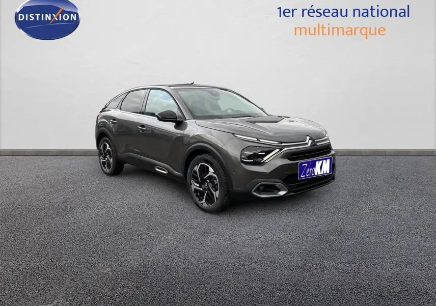 Citroën C4 gris platinium métal vue 3/4 avant droit, mettant en valeur ses lignes modernes et ses jantes bicolores.