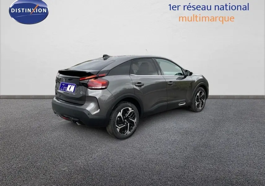 Citroën C4 gris platinium métal vue 3/4 arrière droit, avec jantes bicolores et toit noir contrasté.