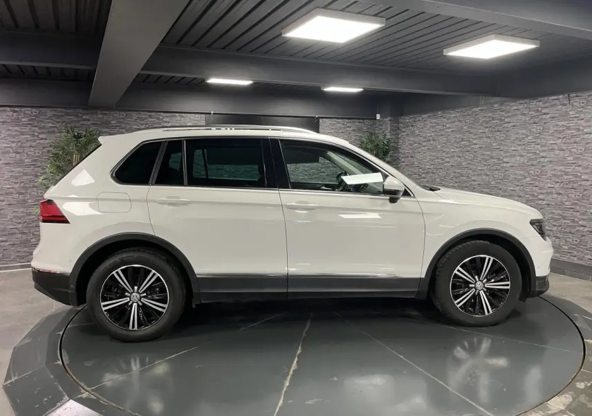 Profil droit du Volkswagen Tiguan blanc 2017 avec jantes alliage noires et garnitures basses noires.